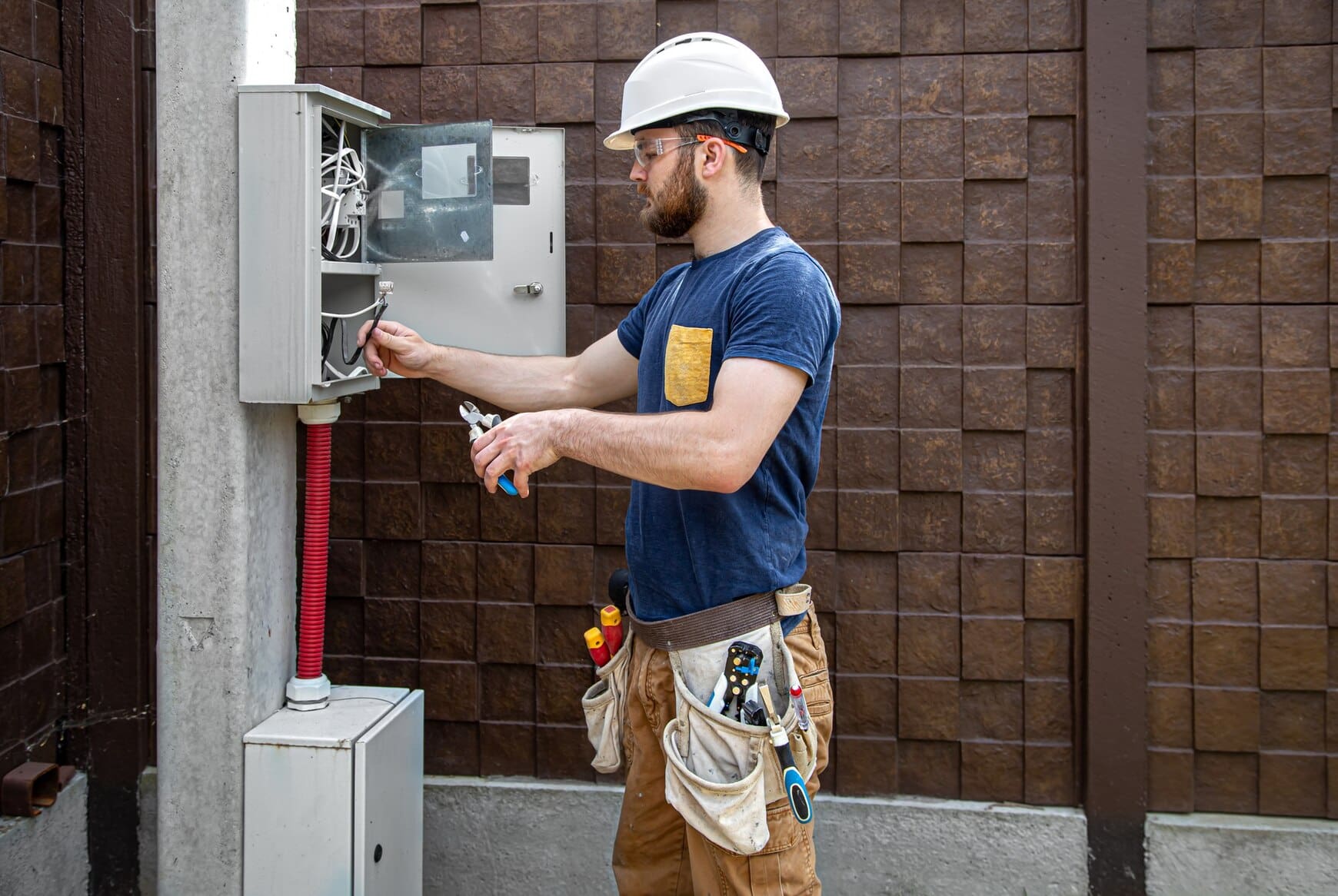electrician-builder-work-examines-cable-connection-electrical-line-fuselage-industrial-switchboard-professional-overalls-with-electrician-s-tool_169016-8632