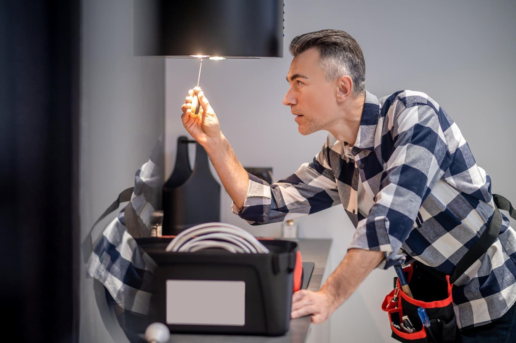 renovation-profile-concentrated-man-touching-screwdriver-lamp-kitchen-range-hood_259150-59261