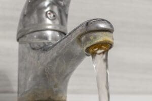 How hard water damages appliances: mineral buildup clogs a faucet